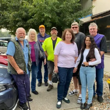 A group of eight people standing together outside a building.