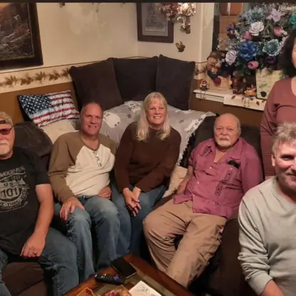 A group of six adults sitting together in a living room.