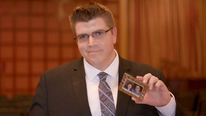 A man holding a picture of a loved one.