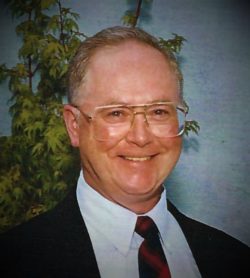 portrait of a smiling man in a suit and glasses