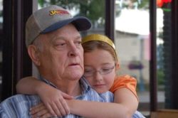 granddaughter giving her grandpa a hug