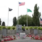 POW MIA Plaza at Washington Memorial Park, flags waving against lush green background.